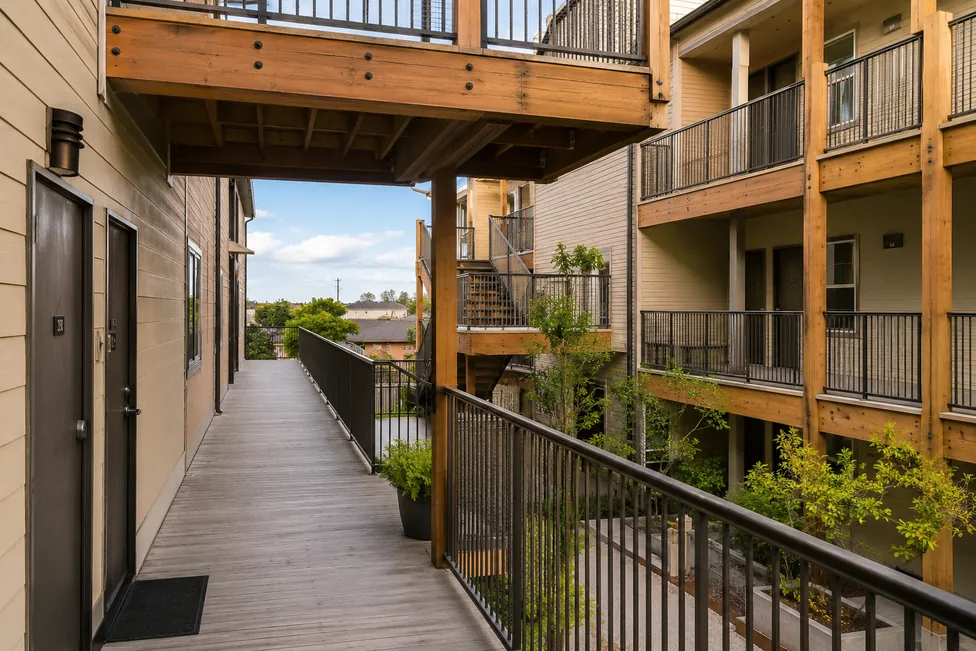 Wood-framed elevated walkway between two multifamily residential buildings — the kind of structure routinely inspected and retrofitted by H2 Seismic Pro.